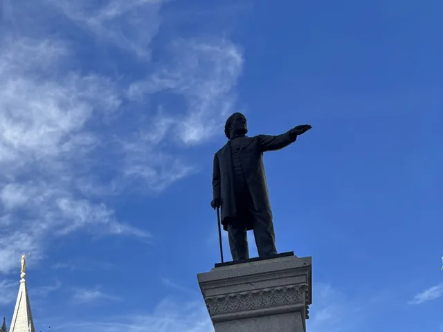 Kész köztéri bronz szobor talapzaton, felemelt karral